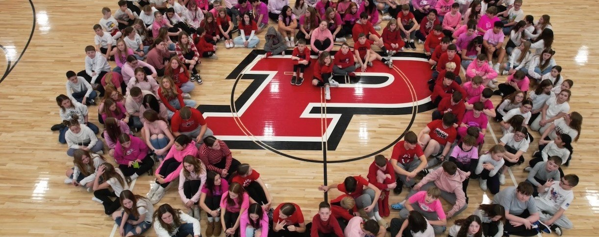 students sitting in the shape of a heart
